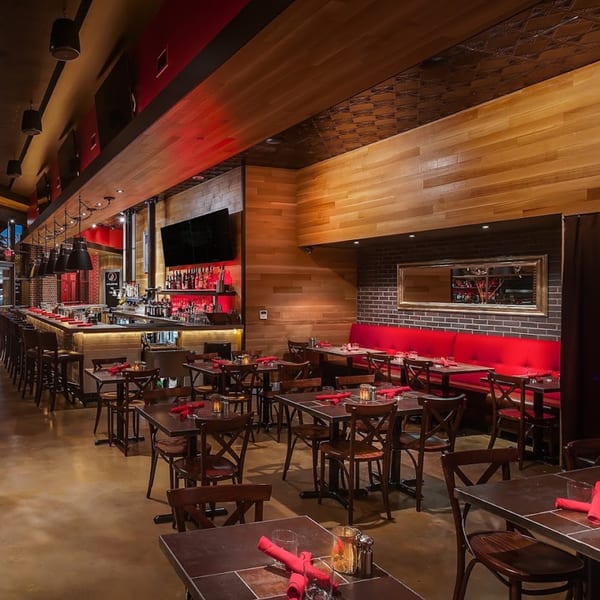 Lena's Wood-Fired Pizza & Tap dining room with a long bar, tables, and red booth seating.