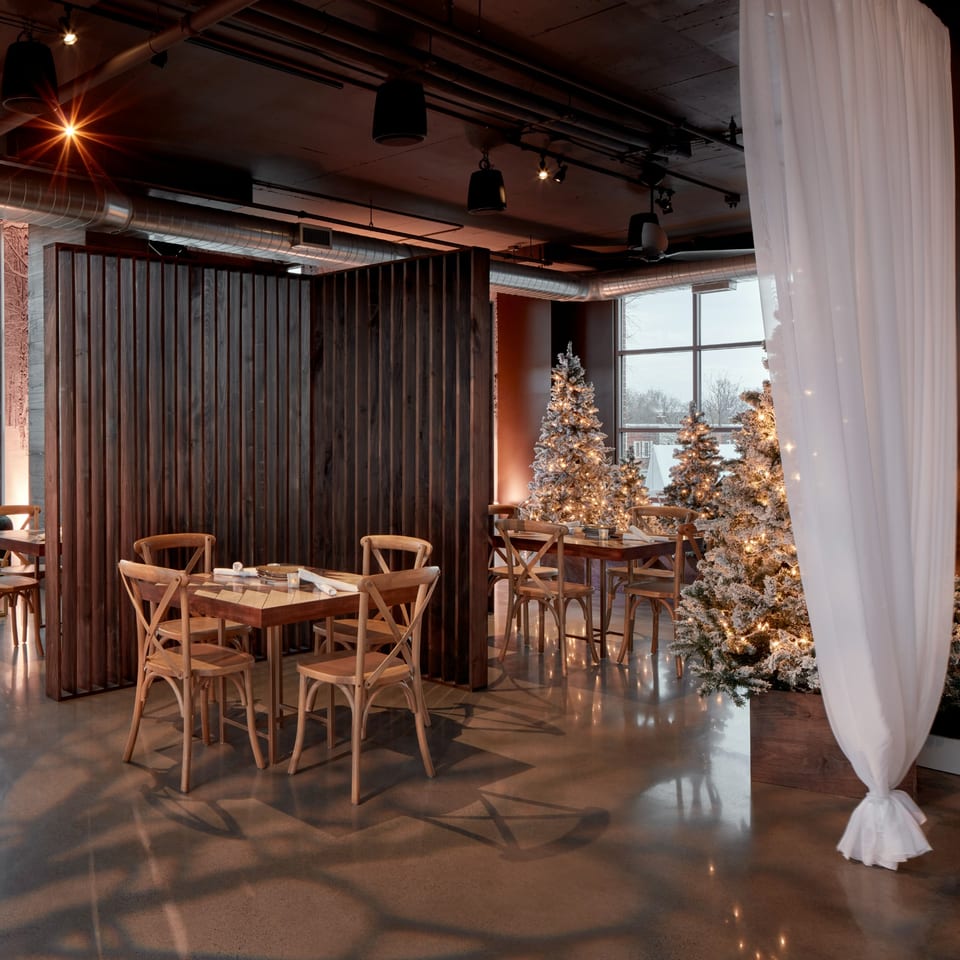 Lena's Wood-Fired Pizza & Tap dining area with wooden tables, chairs, and illuminated Christmas trees.