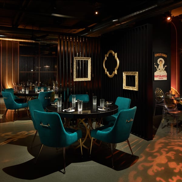 Lena's Wood-Fired Pizza & Tap dining room with dark tables, teal chairs, and warm lighting.