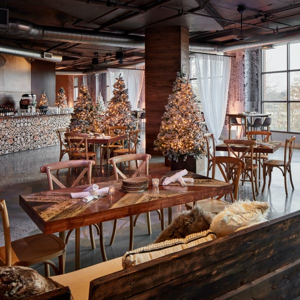 Lena's Wood-Fired Pizza & Tap dining room with Christmas trees, wooden tables, and a unique log bar.