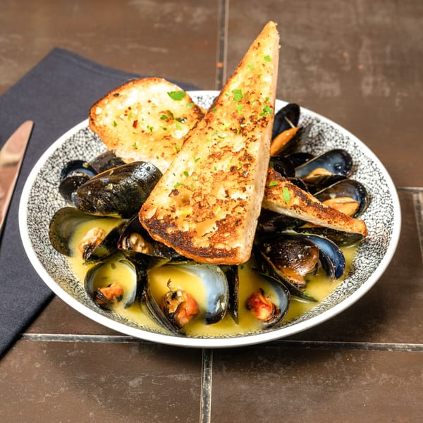 Lena's Wood-Fired Pizza & Tap's mussels in a creamy sauce with toasted garlic bread.