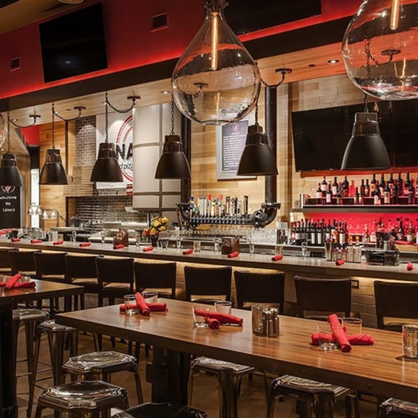 Lena's Wood-Fired Pizza & Tap interior with a long bar, high-top tables, and red accents.