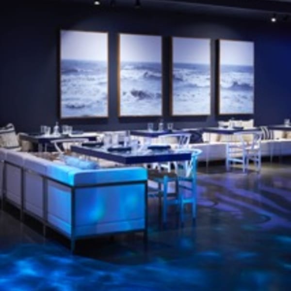 Lena's Wood-Fired Pizza & Tap dining room with blue lighting, tables, and ocean artwork.