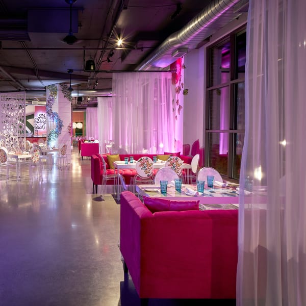 Lena's Wood-Fired Pizza & Tap dining room with hot pink sofas, white tables, and sheer curtains.
