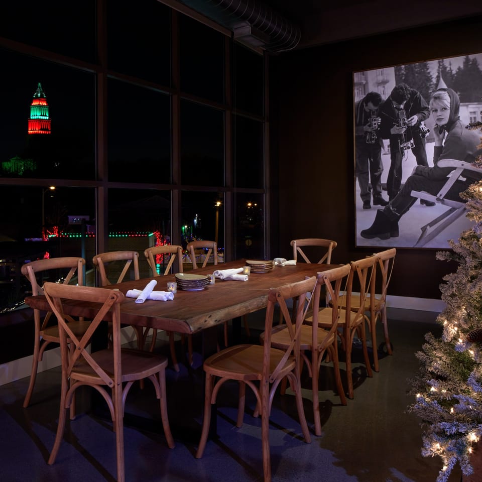A private dining room at Lena's with a long wooden table, chairs, and a large window.
